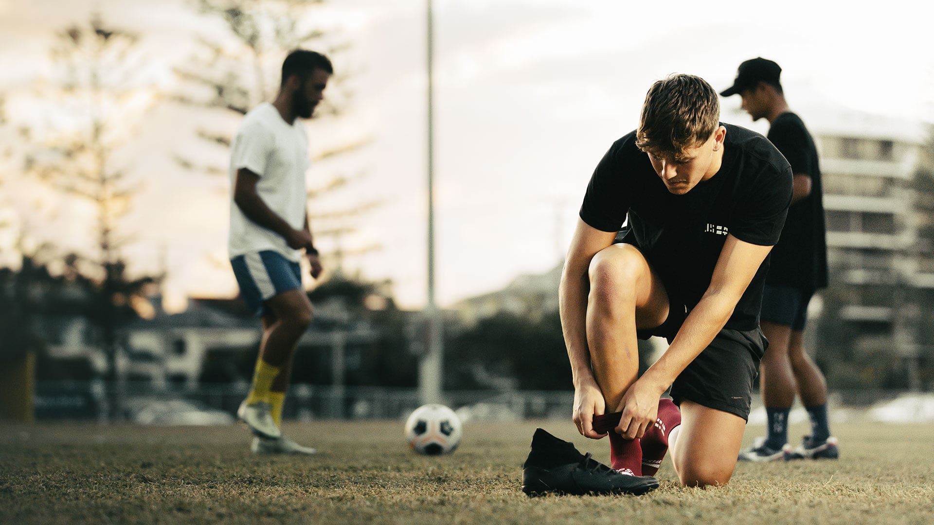 Men kicking soccer ball in Grip Star Socks